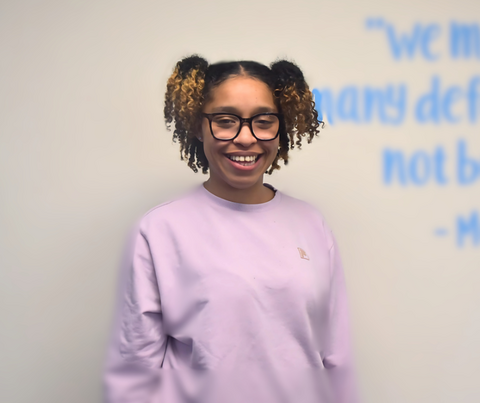 Woman Smiling against wall